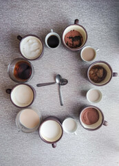 clock composed of cups with elements of a breakfast and to mark the hours spoons  