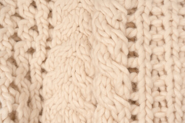 A fragment of beige knitted fabric, knitted from white sheep wool.