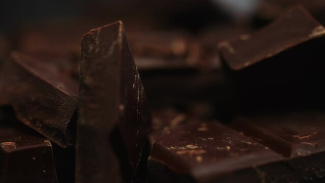 Broken dark chocolate bars. Rotating shot.