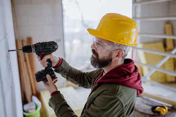 Mature man working on his unfinished house.