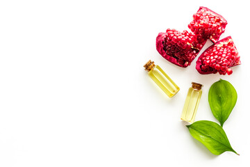 Pomegranate seed essential oil with pomegranate fruit and leaves