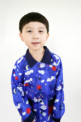 Cute smiling boy in blue shirt looking at camera in isolated studio light background. Portrait of Cute Asian boy in a blue shirt smiling and looking at the camera.