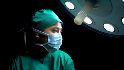 Close-up face eyes doctor in operating room has determined look in eyes, ready perform surgery for patients are in operating room doctor wears hat collect hair cloth scraps for cleanliness safety.