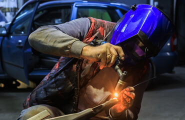 Welder repairing a car part