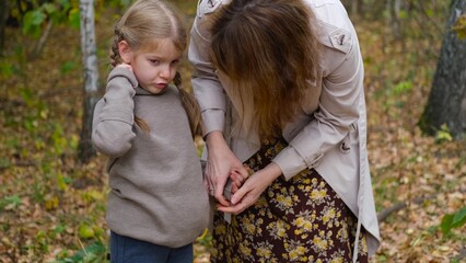 Hello September. A young mother and little daughter walk in the city park in autumn.