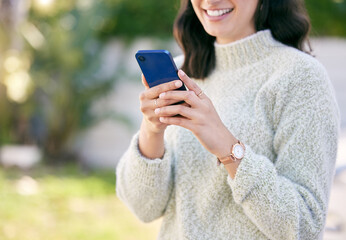 Your texts always make me smile. a woman using her cellphone while standing outside.