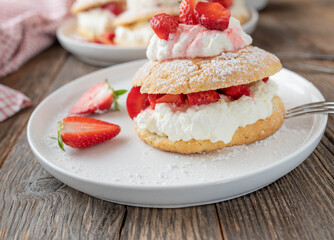 Strawberry pastry with whipped cream and marinated strawberries filling. Traditional british shortcakes baked with short crust