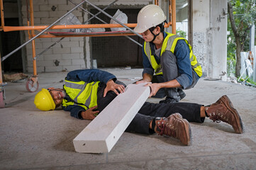 Young Asian builder falls from a height at a construction site. An engineer supervising the...