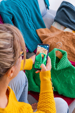 woman typing photo of clothes to sell in used clothing app, Top view from above, vertical
