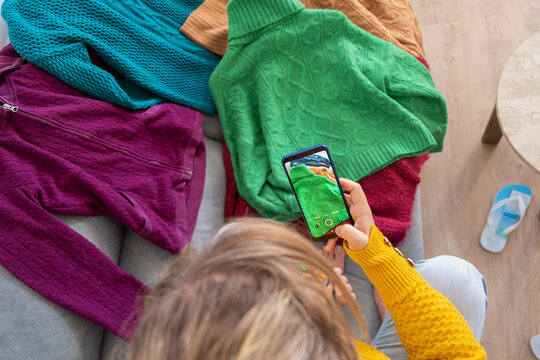 woman typing photo of clothes to sell in used clothing app, Top view from above  horizontal

