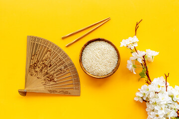 Bowl of rice and asian fan with cherry blossom branch. Asian concept