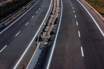 Aerial view of a paved highway road with white markings seen from above. Road repair, travel concept. Separating lanes on the road, a baffle for the safe movement of cars.
