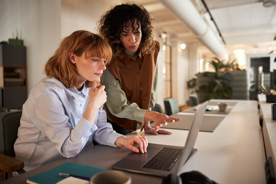 Young businesswomen talking over a laptop
