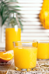 Fresh orange juice on table with slices fruits.