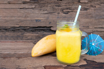 Mango juice fruit smoothies yogurt drink yellow healthy delicious taste in a glass slush for weight loss on wooden background.