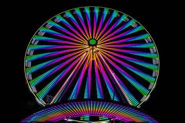 Ferris wheel on a german funfair “Kirmes“ or „Jahrmarkt“ at dark night with many colorful...