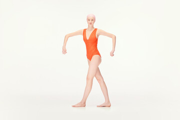 Young girl in red swimsuit and swimming cap standing in position with broad hands isolated over white background. Concept of retro style, sport, fashion, youth, vintage. Copy space for ad