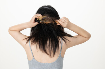 Fototapeta premium Hands combing damaged and tousled hair, back view