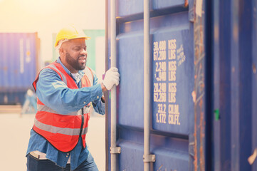 Fototapeta na wymiar African American logistic workers wear helmets and reflection shirts and open containers for inspection and check the condition of containers at warehouse container yard. logistics import export 
