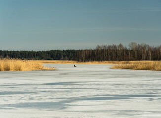 Fisherman on the lake in very cold winter day