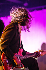 Band playing music and a gig in a venue, close up of a rock band playing guitars and instruments.