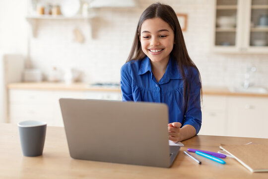 Cheerful Preteen Schoolgirl Using Laptop Learning Online At Home