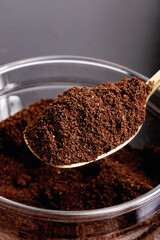 Ground coffee in glass jar and spoon on table