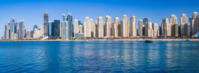Obraz premium Wide panorama of new apartments among hotels on oceanfront in Jumeirah Beach Residence area of Dubai