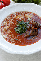 Homemade tomato soup with sourdough bread, grated cheese and parsley.