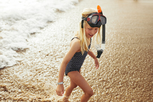 Cute little girl having fun playing at the beach