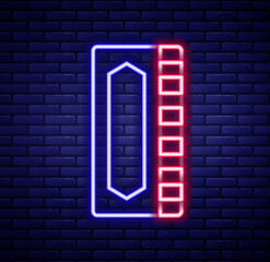 Obraz premium Glowing neon line Harmonica icon isolated on brick wall background. Musical instrument. Colorful outline concept. Vector