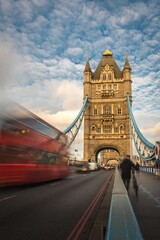 Fototapeta na wymiar Autobús rojo por el puente de Londres con cielo azul de fondo.