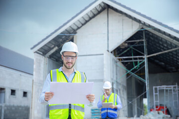 Structural engineer and workers are working on large construction site.