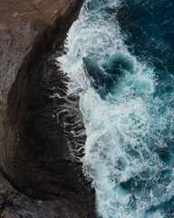 Top Down Aerial View Waves Crashing on Rocks. High quality photo. Near Spitting Cave on Oahu, Hawaii. Shot on DJI Air 2s Drone.