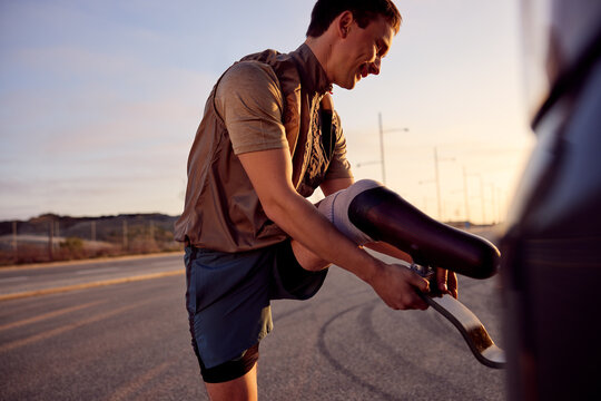 Man putting on a prosthetic running blade before a run