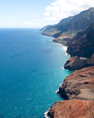 Aerial Na Pali Coast State Park on Kauai, Hawaii. High quality photo. Beautiful mountain backdrop of Hawaii's Na Pali Coastline with 1,000 foot steep cliffs. Shot on Sony A7iv from a helicopter. © Noah
