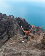 Man hiking to the top of Na Pali Coast State Park on Kauai, Hawaii at sunset.  High quality photo.