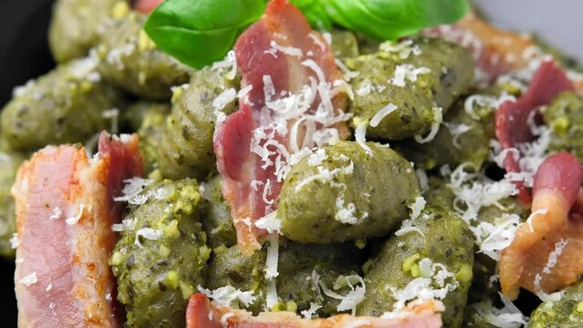 Italian potato gnocchi with green pesto sauce, bacon and parmesan cheese. Healthy food