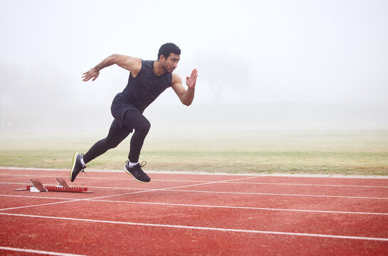 The perfect getaway. Full length shot of a handsome young male athlete running on an outdoor track.