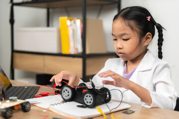 Asian littlle girl constructing and coding robot at STEM class,Fixing and repair mechanic toy car