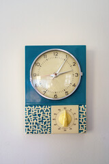 Alte Wanduhr mit Zeitwecker an Wand indoor
