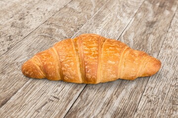 Appetizing fresh tasty croissant on desk