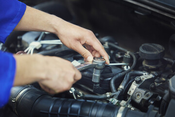 Getting to grips with your engine. High angle shot of an unrecognizable male mechanic working on the engine of a car during a service.