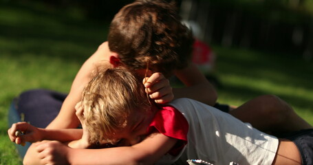 Brothers quarrel outside in backyard. Siblings fighting each other outdoors