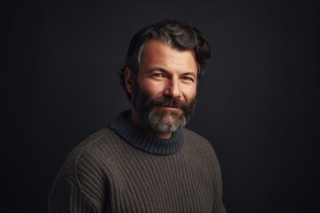 Obraz premium Portrait of a bearded man in a sweater on a dark background