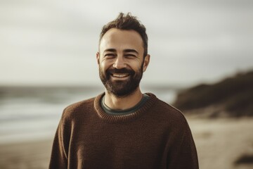 Portrait of a handsome bearded man on the beach at autumn day