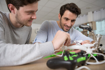 young male engineer with technician programming a drone