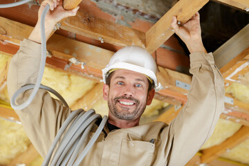 electrician installing ventilation in ceiling