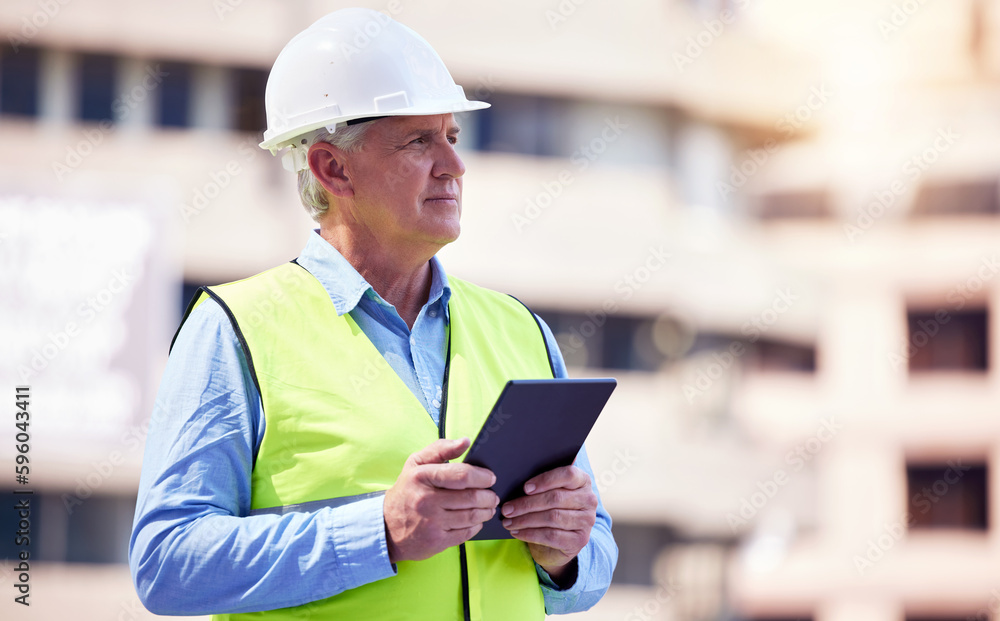 Poster managing the site online. a handsome mature male construction worker using a tablet while standing o