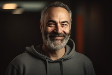 Obraz premium Portrait of a mature man in a sweatshirt on a dark background
